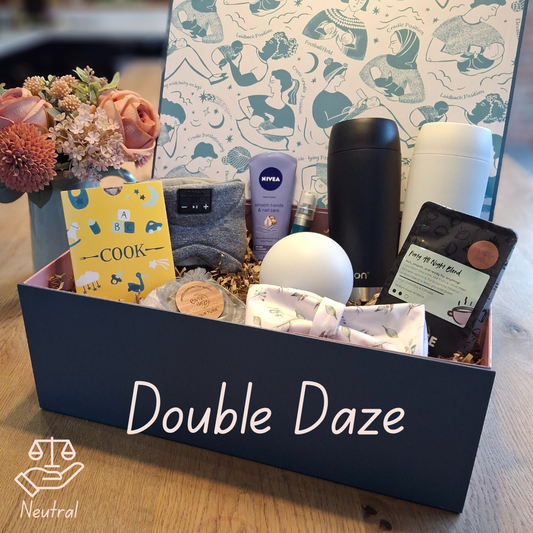 Open gift hamper for new parents with thermos mugs, coffee, night light, cook voucher, bluetooth eye mask, moisturiser, hand sanitiser, decision coin and reusable nappy bag