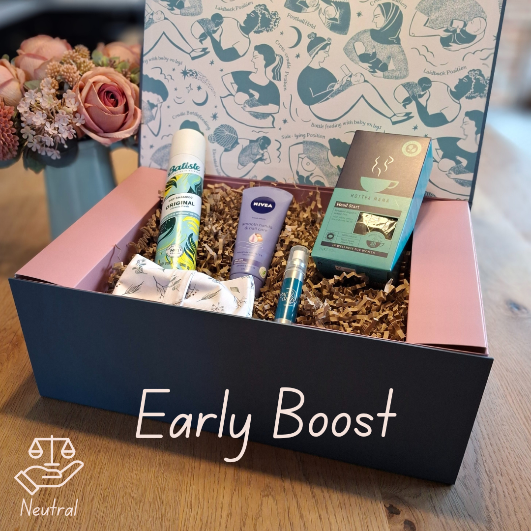 Gift box labeled 'Early Boost' with a mix of postpartum gift products on a wooden surface